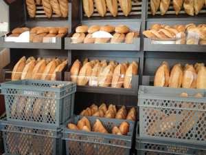 Satışa hazırlanmış ekmekler. Plastik kasalara ve satılmak için tezgaha dizilmiş bir çok ekmek var. 